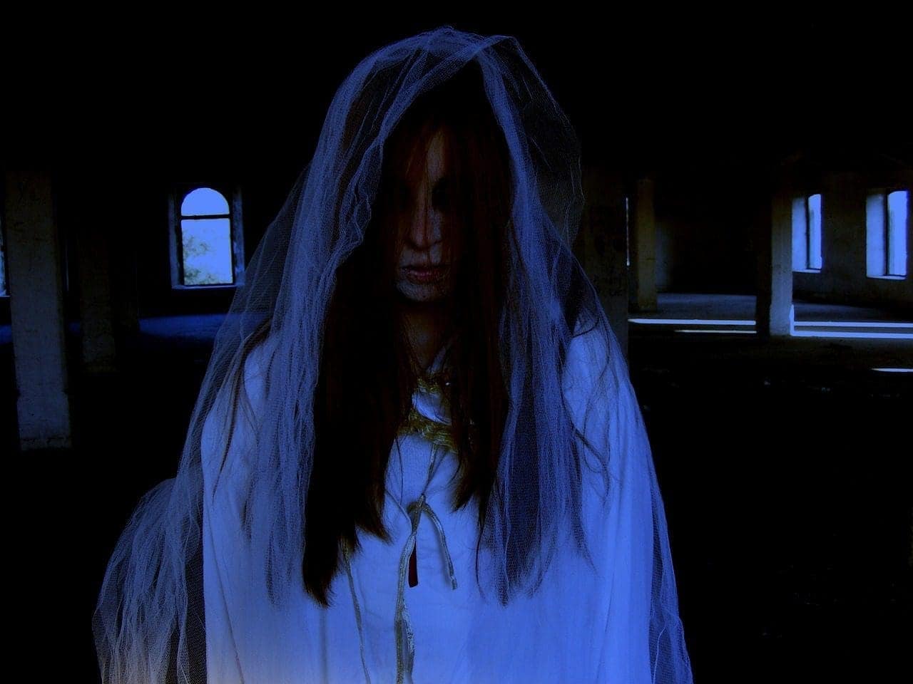 A close-up of a woman ghost with open hair wearing white. Fever is organizing a ghost Night Walk in Philadelphia.