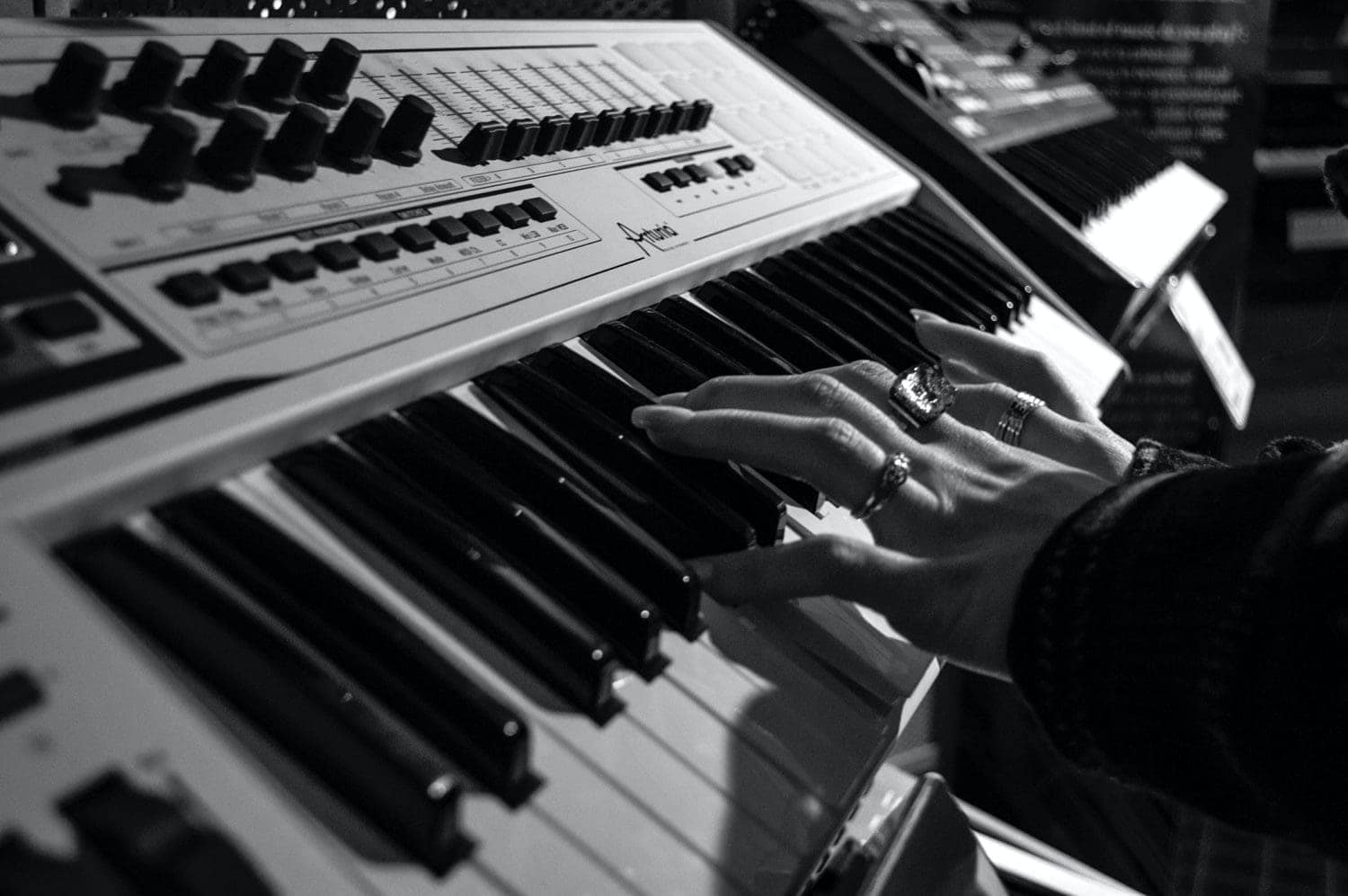 A black and white photo of a piano played by a person.