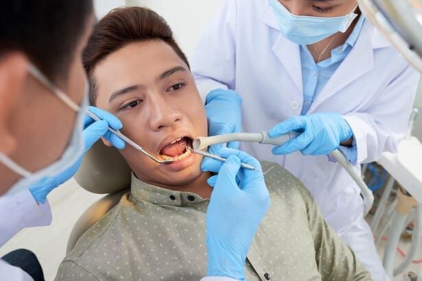 Asian dentist performing dental checkup on patient